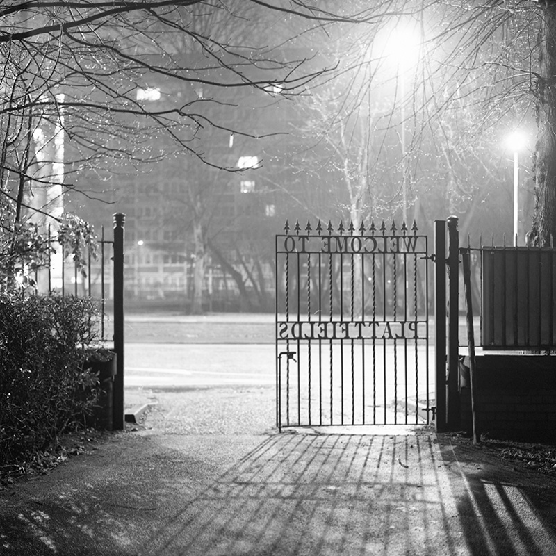 The gates of Platt Fields Park at night