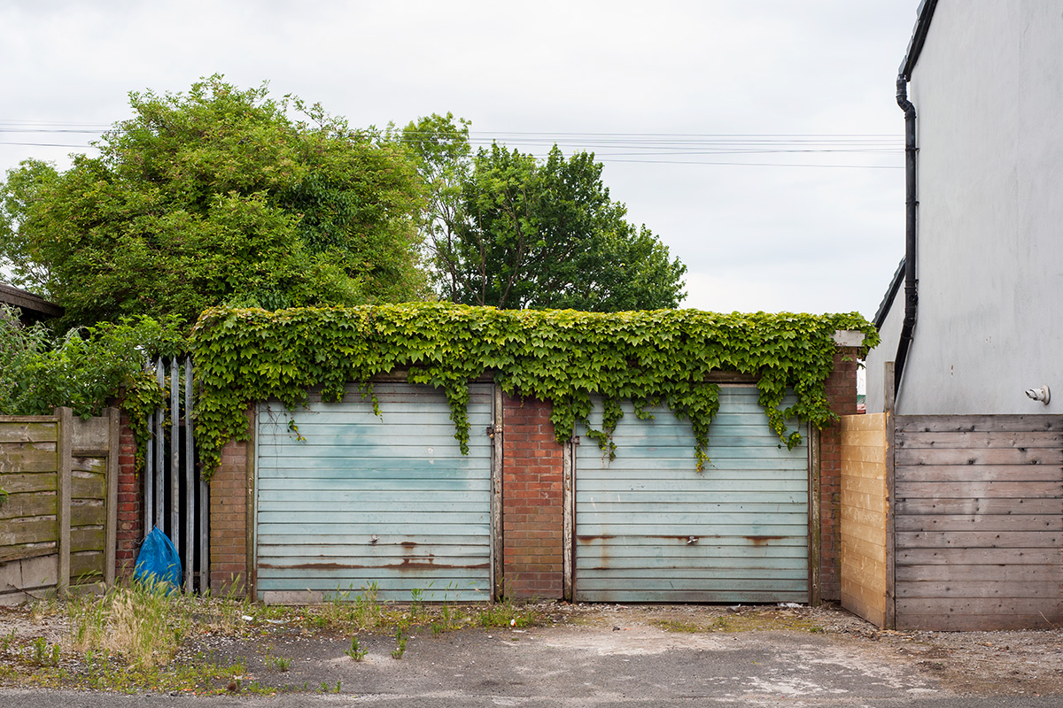 Two garages overhanging with ivy