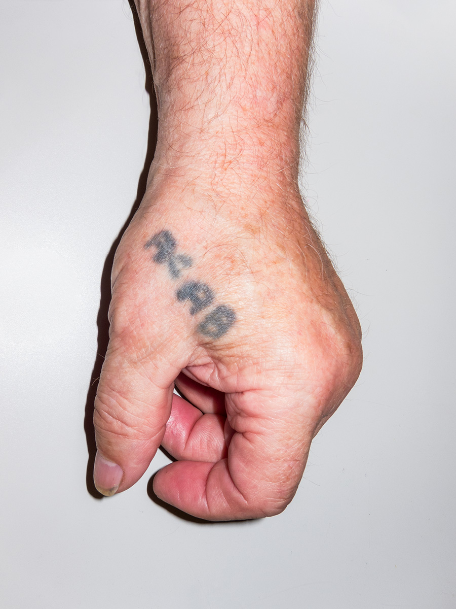 A hand tattoo reading ACAB