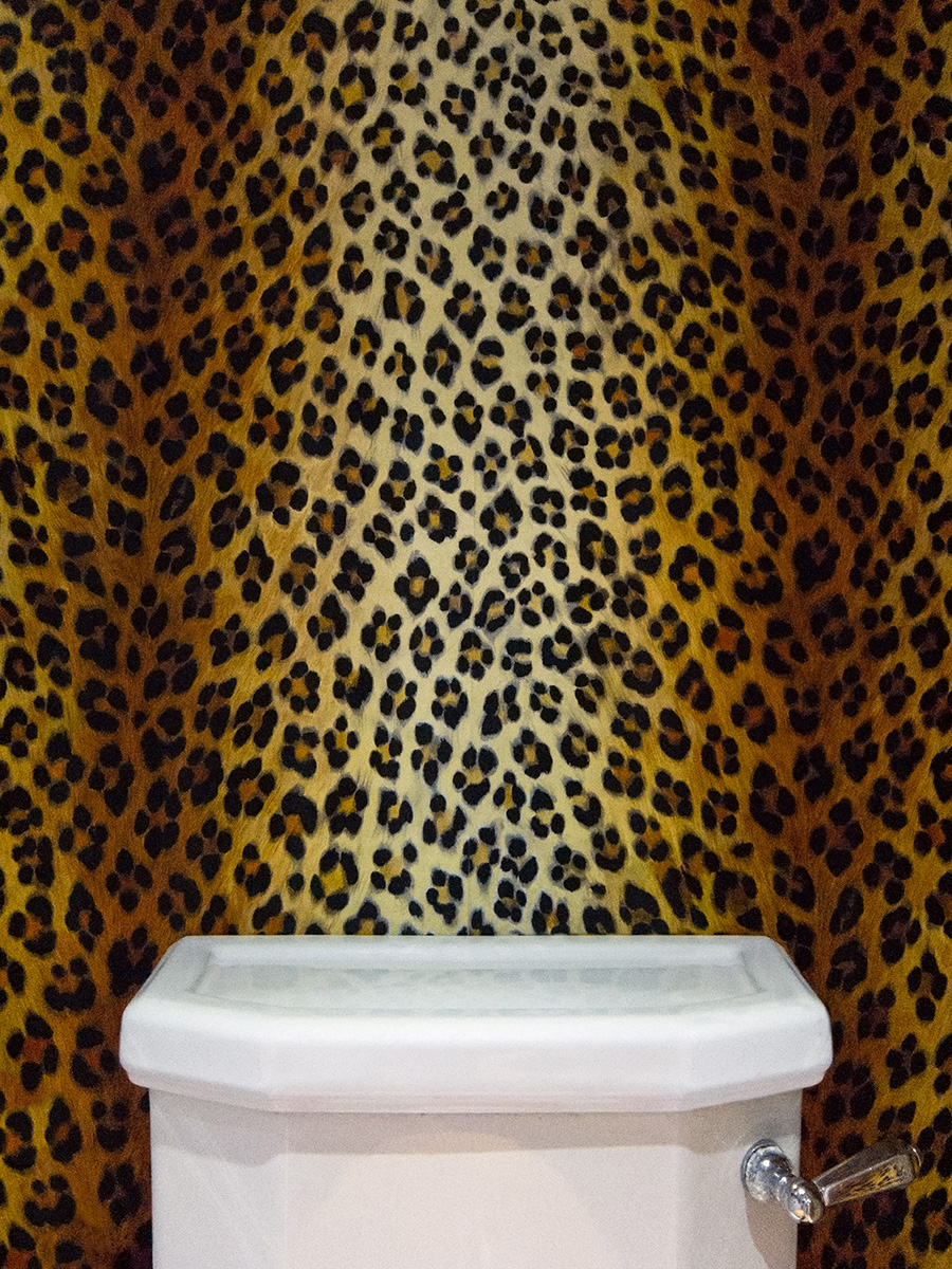 A toilet with leopardskin wallpaper