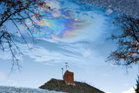 A reflection in an oily puddle, to illustrate the phrase bruised air, a metaphor for air pollution.