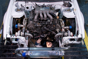 A mechanic working on a Team Japspeed drift car